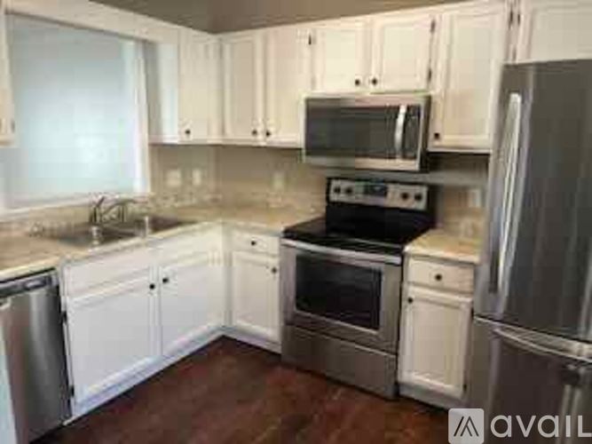 A kitchen with white cabinets and stainless steel appliances.