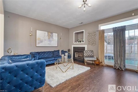 A living room with a blue couch and a fireplace.