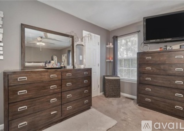 A bedroom with a large mirror and a TV on the wall.