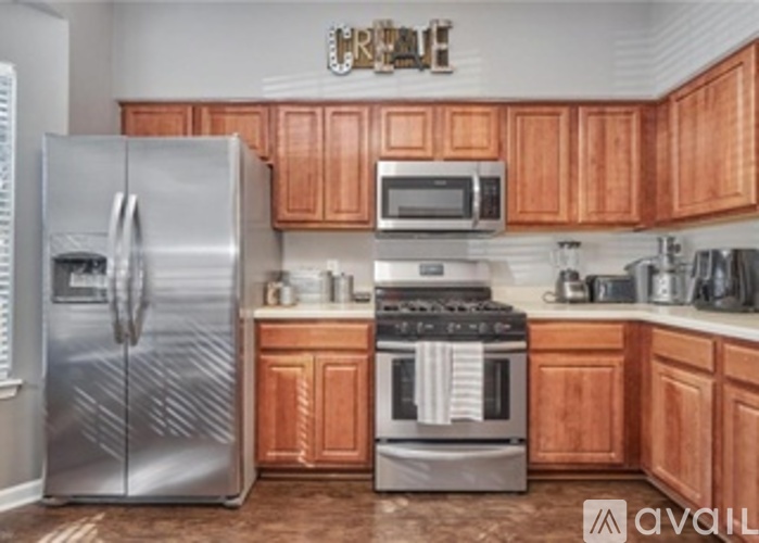 A kitchen with wooden cabinets and a stainless steel refrigerator.