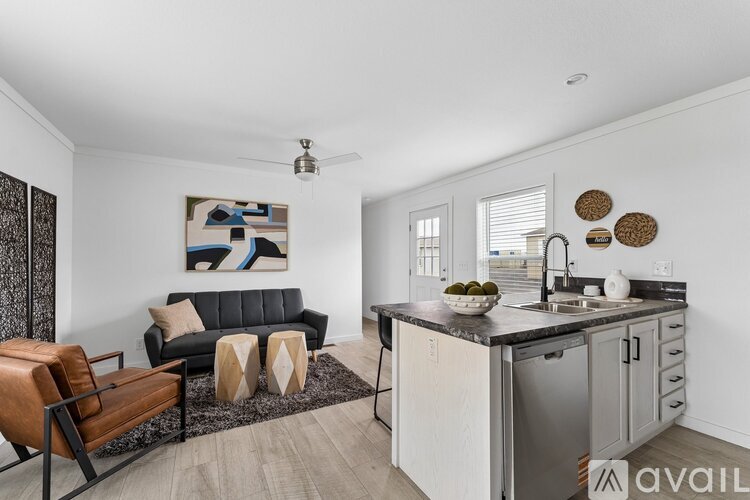A modern kitchen with a black couch and a painting on the wall.