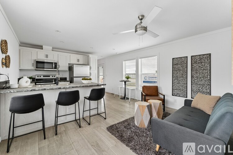 A modern kitchen with a bar area and a living room area.