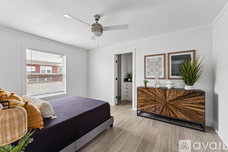 A bedroom with a bed, dresser, and window.