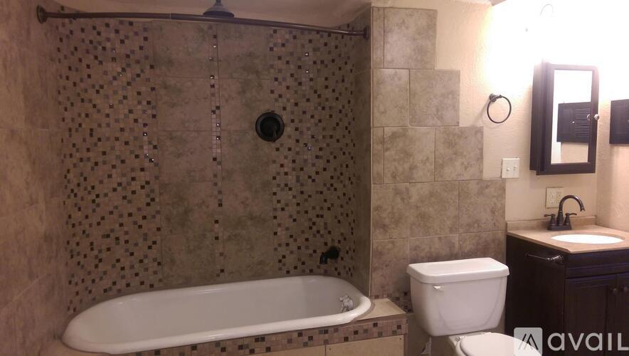 A bathroom with a tub, toilet, and sink.