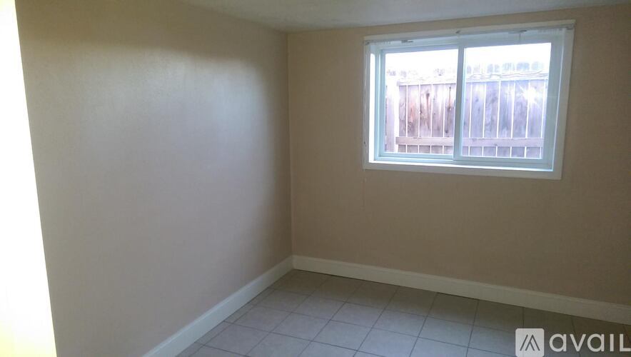 A room with a window and a tiled floor.