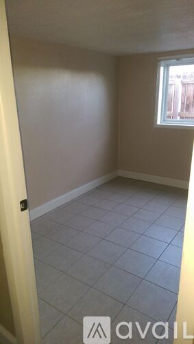 A room with a window and tiled floor.