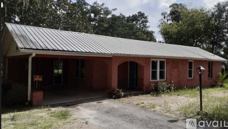 A red brick building with a metal roof is available for purchase.