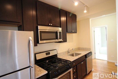 A kitchen with a stove, oven, refrigerator, and microwave.