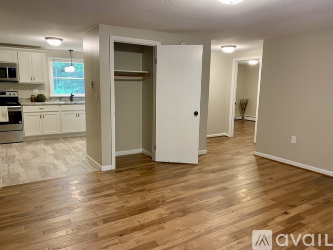 A kitchen with white cabinets and a wooden floor.