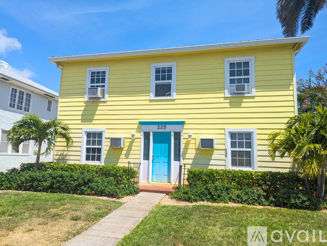 A yellow house with a blue door and windows.