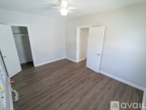 A room with a ceiling fan and wooden flooring.