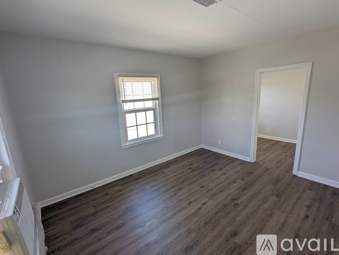 A room with wooden flooring and a window.