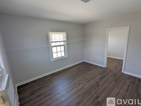 A room with wooden flooring and a window.