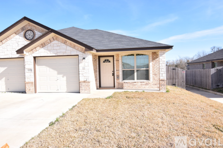 A house with a brown roof and a white garage door is for sale.