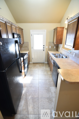 A kitchen with black appliances and brown cabinets.