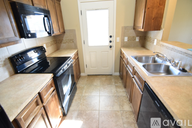 A kitchen with black appliances and wooden cabinets.