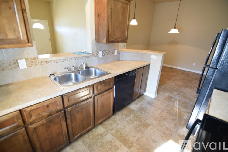 A kitchen with wooden cabinets and a tiled floor.