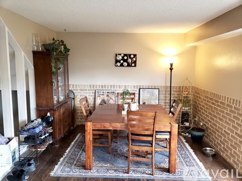 A dining room with a wooden table and chairs.