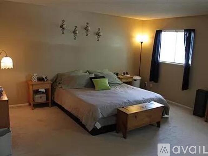 A bedroom with a bed, nightstand, and lamp.