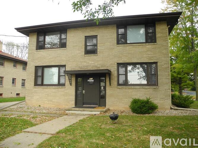 A two-story house with a black front door and windows.