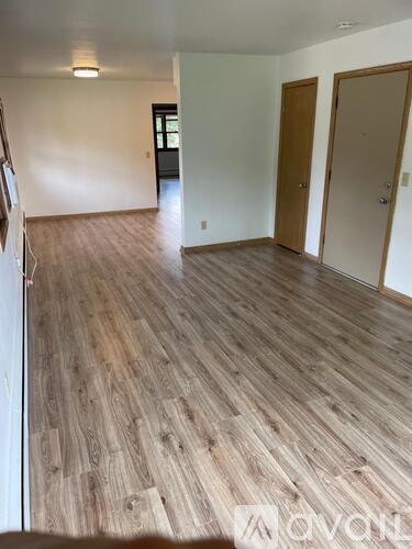 A room with wooden flooring and white walls.