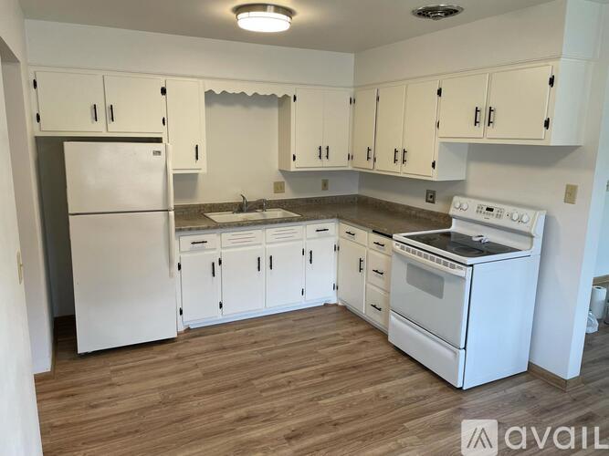 A kitchen with white appliances and cabinets.