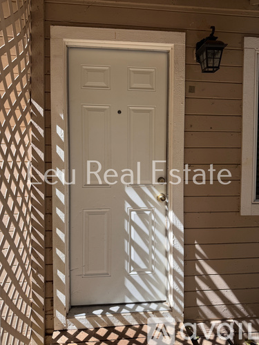 A white door is in the center of a wall with a shadow pattern on the floor.