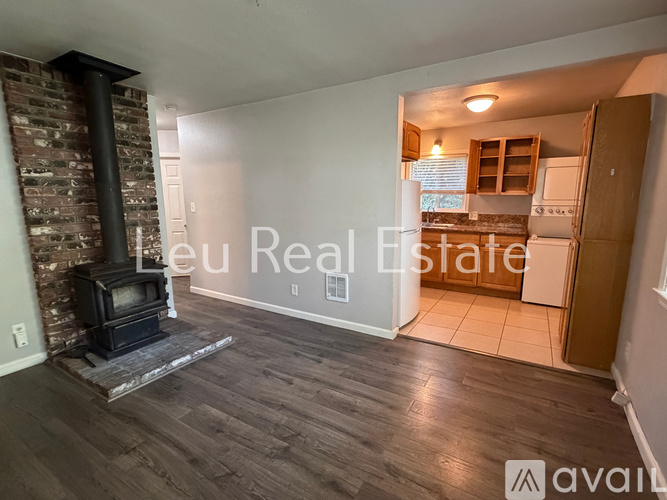 A wood burning stove in a living room with a brick wall.