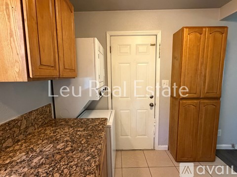 A kitchen with wooden cabinets and a granite countertop.