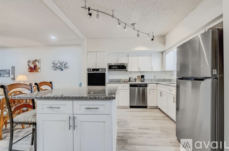 A kitchen with white cabinets and a granite countertop.