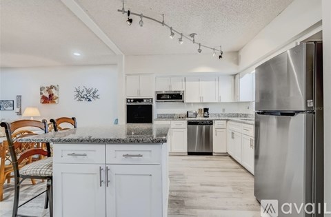 A kitchen with white cabinets and a granite countertop.