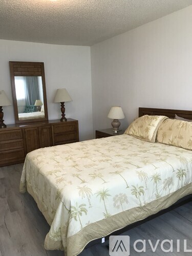 A bedroom with a bed, nightstand, and a dresser with a mirror.