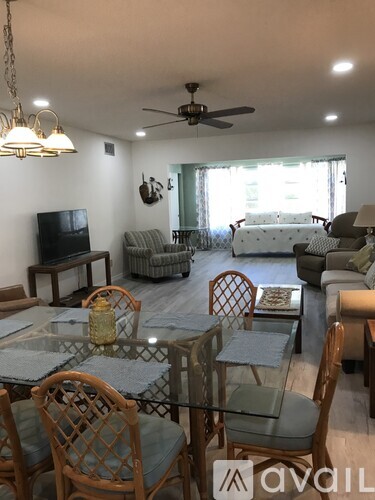 A living room with a glass table and chairs.