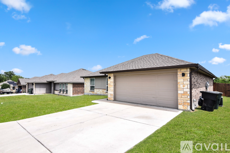 A house with a garage and a driveway in front of it.