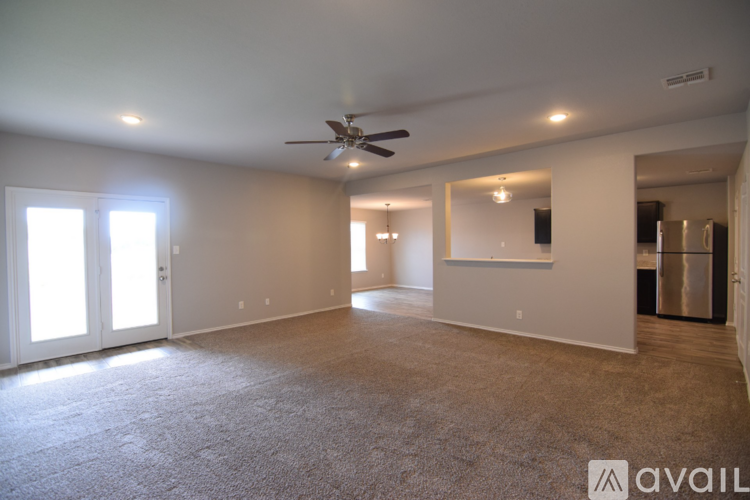 A spacious room with a ceiling fan and carpeted floor.