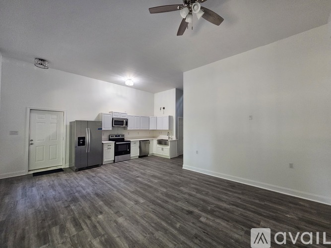 A spacious kitchen with a refrigerator, oven, and microwave.
