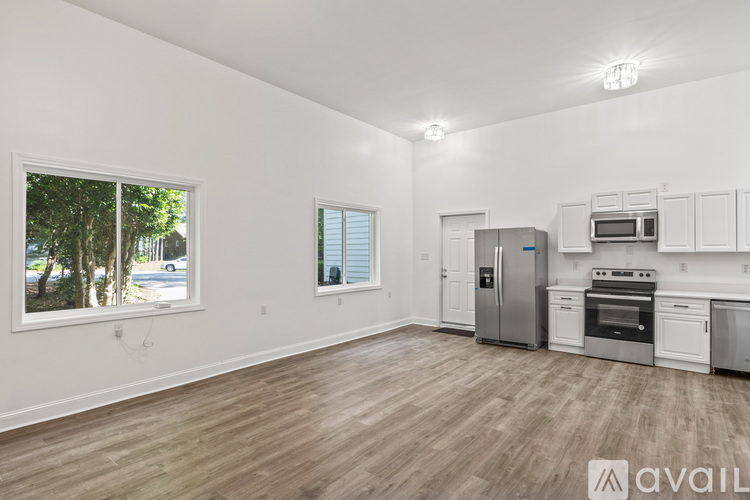 A kitchen with a stainless steel refrigerator and white cabinets.