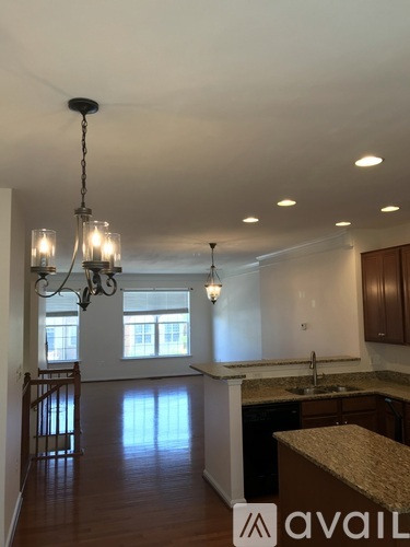 A kitchen with a granite counter top and a chandelier.