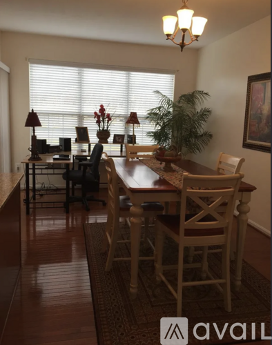 A dining room with a wooden table and chairs.