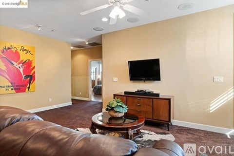 A living room with a brown leather couch and a painting on the wall.