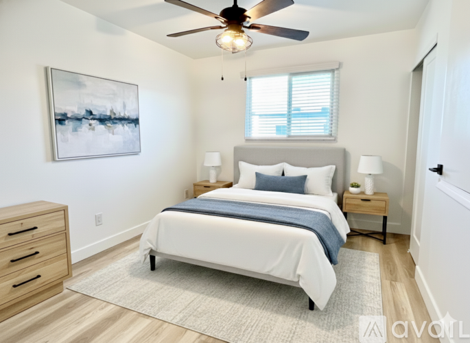 A bedroom with a bed, nightstands, and a ceiling fan.