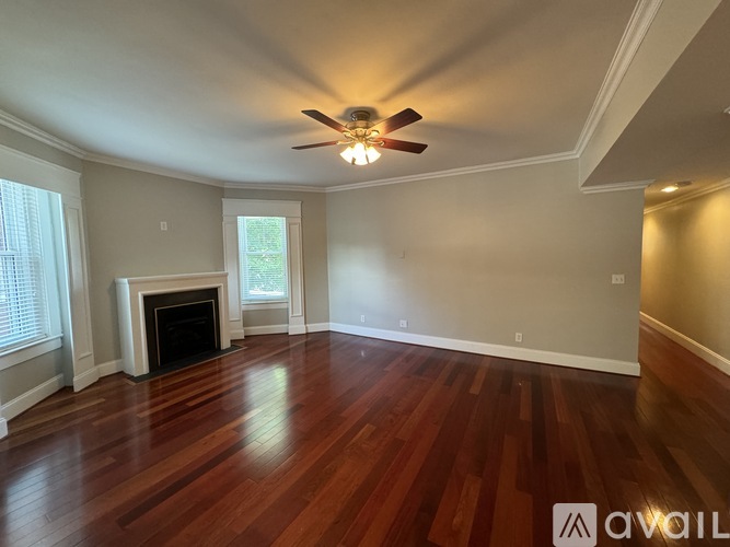 A living room with wood floors and a fireplace.