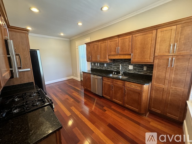 A kitchen with wooden cabinets and a black stove top.