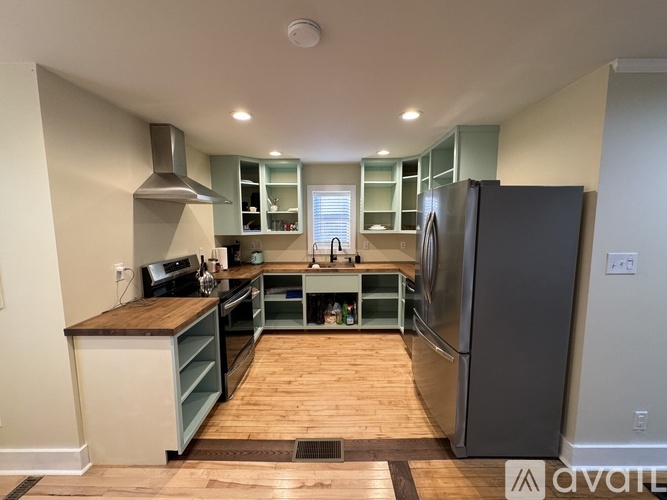A kitchen with a refrigerator, oven, and sink.