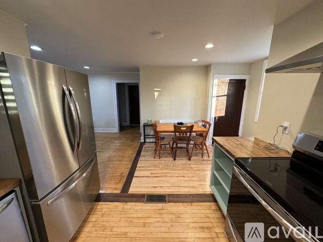 A kitchen with a wooden floor and stainless steel appliances.