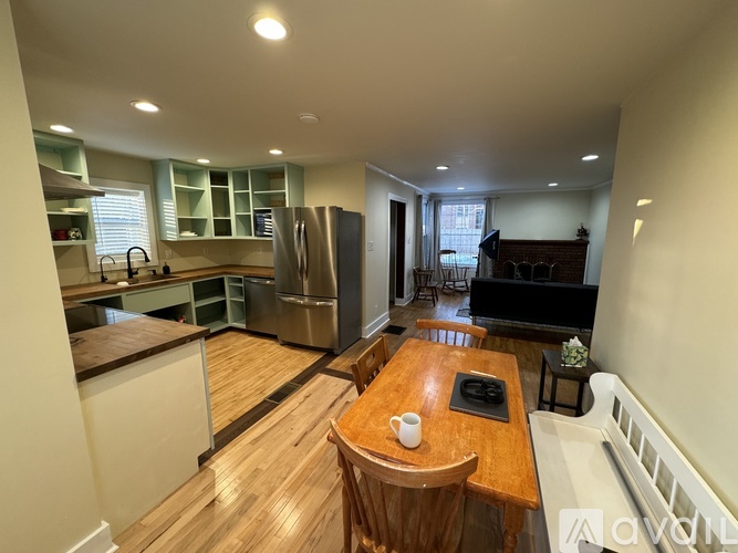 A kitchen with a wooden table and chairs in the middle of the room.