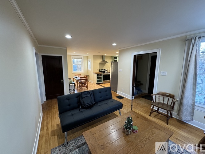 A living room with a black couch and a wooden coffee table.