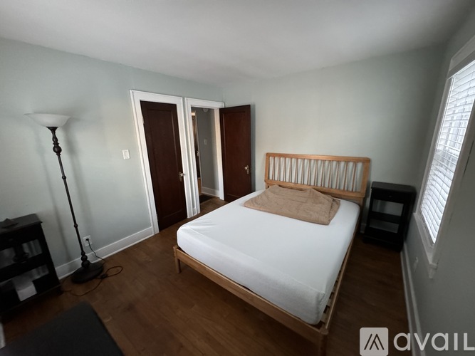 A bedroom with a bed, nightstand, and lamp.