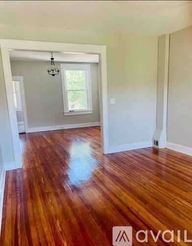 A room with wooden floors and a chandelier.