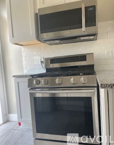 A kitchen with a stainless steel oven and microwave above it.